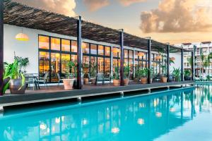un complejo con piscina frente a un edificio en El Beso Adults Only at Ocean Riviera Paradise All Inclusive en Playa del Carmen