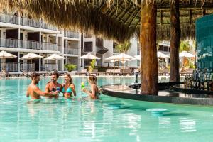 un grupo de personas en la piscina de un complejo en El Beso Adults Only at Ocean Riviera Paradise All Inclusive en Playa del Carmen