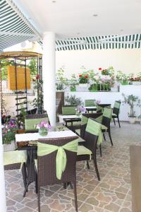 ein Restaurant mit Tischen, Stühlen und Blumen in der Unterkunft Семеен Хотел Идън in Sweti Wlas