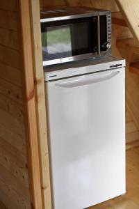 un forno a microonde seduto sopra un frigorifero di Świetny Spokój u Rybaków Uhnin 123 a Uhnin