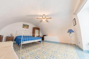 una camera con letto e ventilatore a soffitto di Residenza Stella di Marina a Vietri