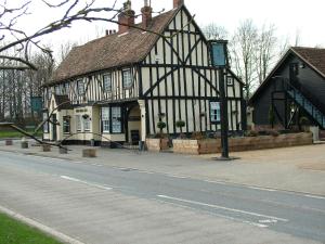 an old black and white building on the side of a street at Thistle Cottage in Mildenhall