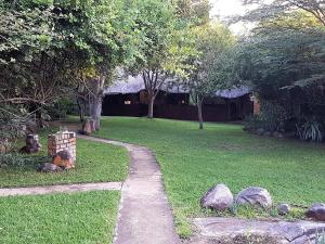 a path in a yard with rocks and trees at River Hill Lodge in Komatipoort