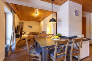 a dining room and living room with a table and chairs at BERGSUCHT-Ruhpolding, Traumlage am sonnigen Südhang, kostenlose Parkplätze, schnelles WLAN, ruhige Sackgasse, NETFLIX inklusive in Ruhpolding