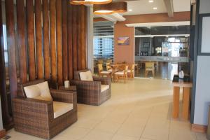 a lobby with wicker chairs and a dining room at Nelson Praia Hotel in Cassino +37 photos