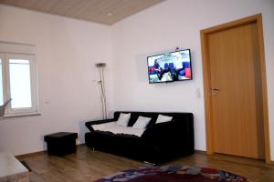 - un salon avec un canapé et une télévision murale dans l'établissement Apartment Kraemer Dax, à Mehren