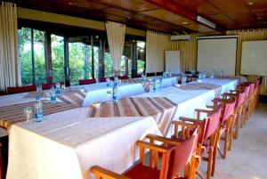 een lange rij tafels en stoelen in een kamer bij River Hill Lodge in Komatipoort