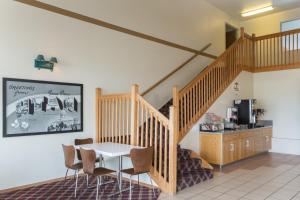 a dining room with a staircase and a table and chairs at Super 8 by Wyndham Green River in Green River