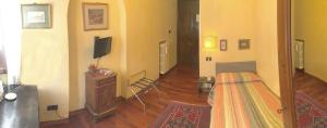 a living room with a bed and a television at Locanda Borgonuovo in Ferrara