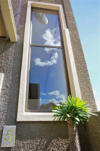 a window on the side of a building with clouds in the sky at Hartmann Suites Serviced Self-Catering Apartments in Windhoek