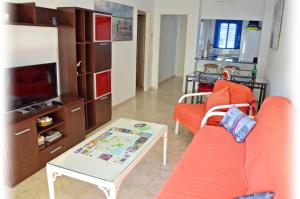a living room with an orange couch and a coffee table at Apartamento Benalmadena Costa in Benalmádena