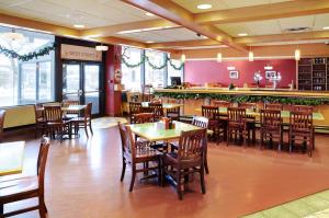 um restaurante com mesas e cadeiras e um bar em Greenwood Inn & Suites em Corner Brook