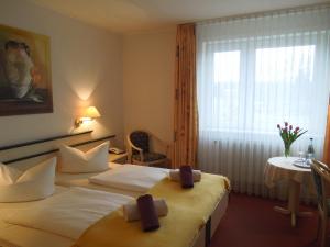 a hotel room with two beds and a window at Hotel Schnehagen in Bad Fallingbostel