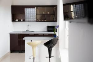a kitchen with a counter and a sink and stool at Noclegi Prestige in Nowy Sącz