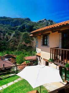 a house with a white umbrella in the yard at Casa Rural La Riba in Sames