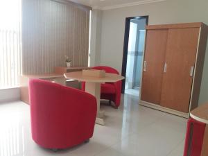 a room with a table and two red chairs at Hotel Coimbra in Tucuruí