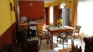 a kitchen with a table and chairs and a refrigerator at Cabaña Don Claudio in Osorno