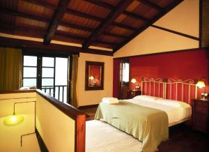 SamesにあるCasa Rural La Ribaの赤い壁のベッドルーム1室(ベッド1台付)