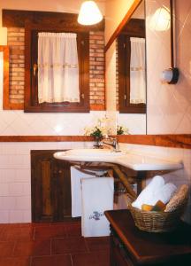 a kitchen with a sink and a basket of towels at Casa Rural La Riba in Sames