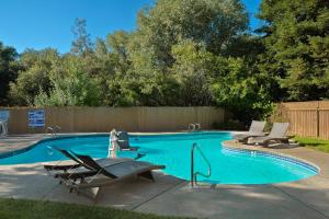 a swimming pool with two lounge chairs next to it at Lake Natoma Inn in Folsom