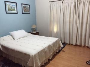 a bedroom with a white bed and a window at La Maria Josefa in San Rafael