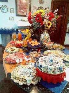 a table with plates of food and a vase of flowers at B&B Cà d'Artisti in Caorle