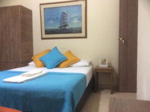 a bedroom with a bed with blue and yellow pillows at The Palma Home in Bogotá