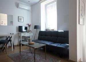 a living room with a black couch and a table at Casa da Viola - Faro in Faro