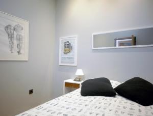 a bedroom with a bed with black pillows on it at Casa da Viola - Faro in Faro