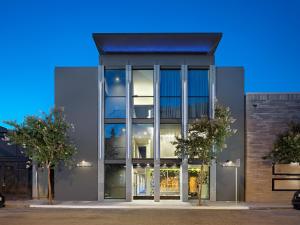 a building with large glass windows with trees in front at Hotel Keen in Palo Alto