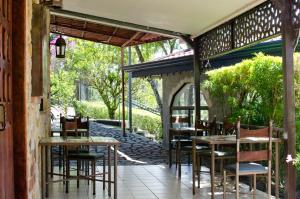 an outdoor dining area with tables and chairs at Gingerbread Restaurant & Hotel in Nuevo Arenal