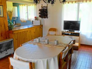 a room with a table with chairs and a television at La Casa del Tata in Potrerillos