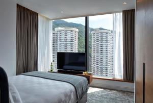 a hotel room with a bed and a large window at Little Tai Hang in Hong Kong
