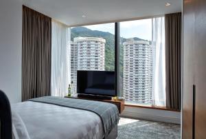香港Little Tai Hang 酒店及服务式公寓的一间带床和大窗户的酒店房间