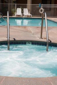 a swimming pool with two chairs in the water at Premier Inns Thousand Oaks in Thousand Oaks