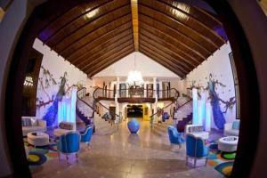 un vestíbulo con sillas azules y una lámpara de araña en Villas Privadas en Palma Real, en El Corazón