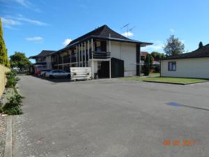 a parking lot in front of a house at Ambassador Motel in Palmerston North