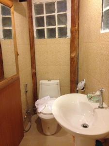 a bathroom with a toilet and a sink at Treasure Inn Khaoyai in Mu Si
