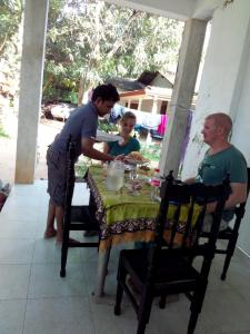 um homem e uma mulher sentados à mesa em Osheen Family Guest House em Pollonaruva