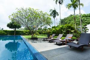 班巴克洛的住宿－Baan Yamu Private Villa，游泳池旁的一排躺椅
