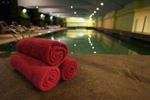 a stack of towels sitting next to a swimming pool at Hotel Royal Kuala Lumpur in Kuala Lumpur