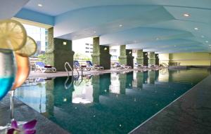 a swimming pool in a hotel with chairs at Hotel Royal Kuala Lumpur in Kuala Lumpur