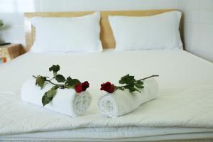 2 almohadas blancas con rosas en una cama en Duong Hieu Guesthouse, en Phu Quoc