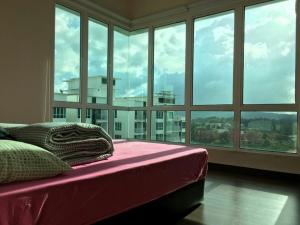 a bedroom with a bed and a large window at Sandakan Spacious and Comfortable Pool View Condo in Sandakan +28 photos