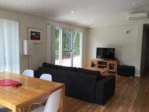 a living room with a black couch and a table at Cape Villas Dunsborough Unit 2 in Dunsborough