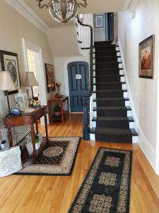 a room with a staircase with a blue door and a rug at Quartermain House Bed & Breakfast in Fredericton