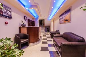 una sala de espera con sofá y sillas y un bar en Calypso Beach Hotel en Paralia Katerinis