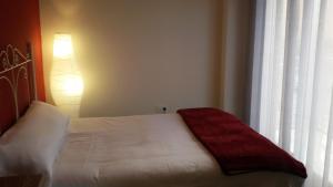 a bedroom with a bed with a red blanket on it at Apartamento El Mirlo Blanco in Villena