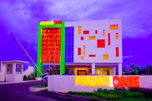 a building with a neon sign in front of it at Front One Hotel Purwodadi in Purwodadi