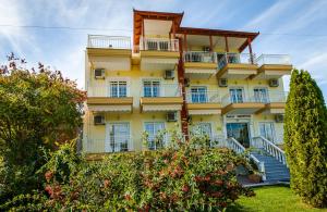 a tall yellow building with stairs in front of it at Calypso Beach Hotel in Paralia Katerinis